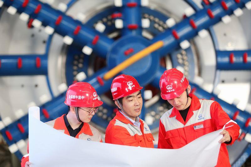 贺开伟在车间和团队研究技术方案图一